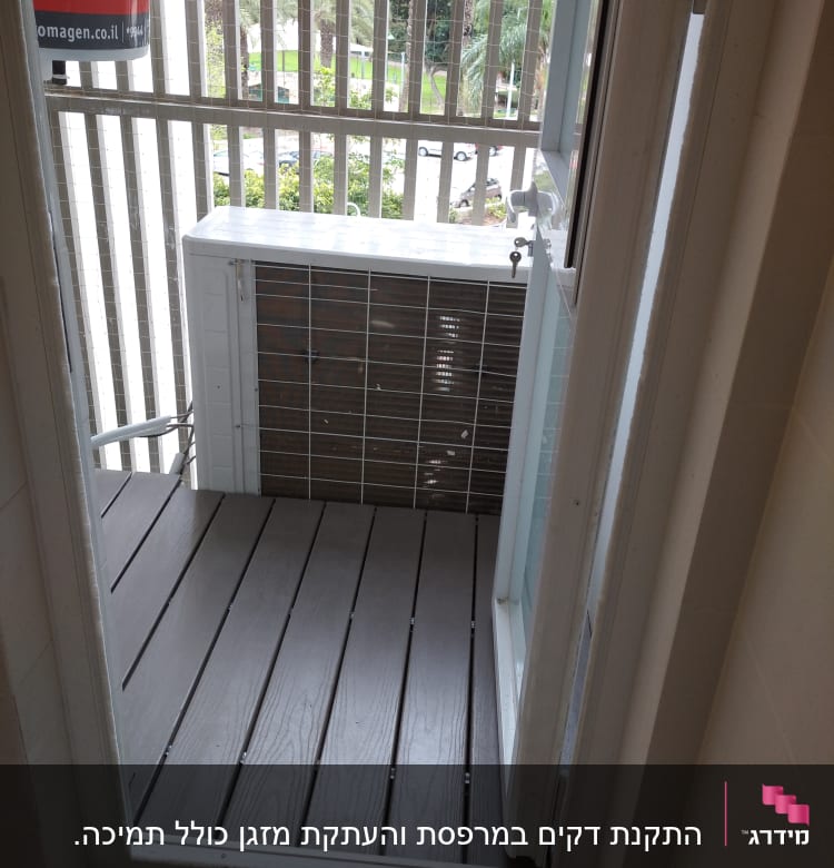 רצפת עץ במרפסת קטנה עם מעקה ברזל